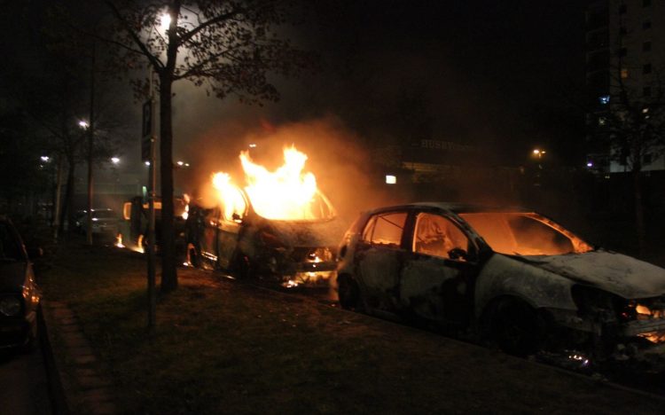 Genrebild. Brinnande bil från upploppen i Husby, Stockholm, 2013. Foto: Telefonkiosk/Wikipedia