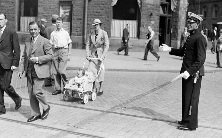Polis dirigerar människor vid övergångsställe över Birger Jarlsgatan vid Nybroplan. Foto: Stockholms stadsmuseum.